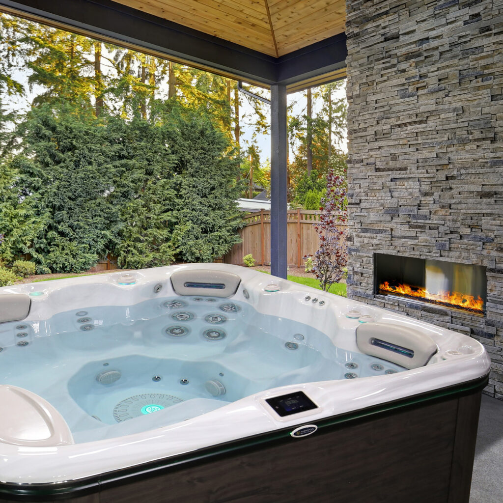 Signature Series 679 Hot Tub beside an outdoor fireplace